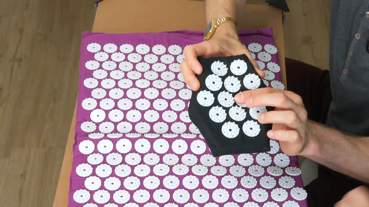 Nahaufnahme einer Shiatsu‑Matte mit Fokus auf die Noppen und einem separaten Aufsatz in der Hand