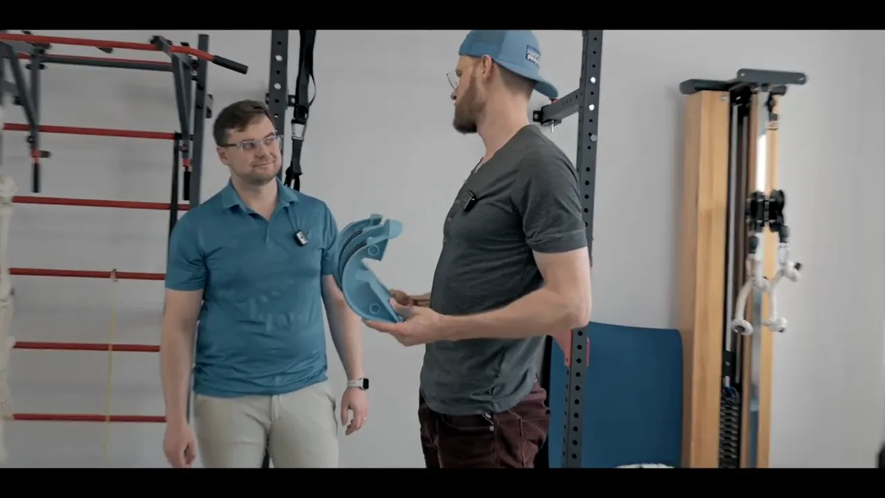 Zwei Therapeuten diskutieren das blaue Wadendehner‑Set; einer hält die Hälften in der Hand