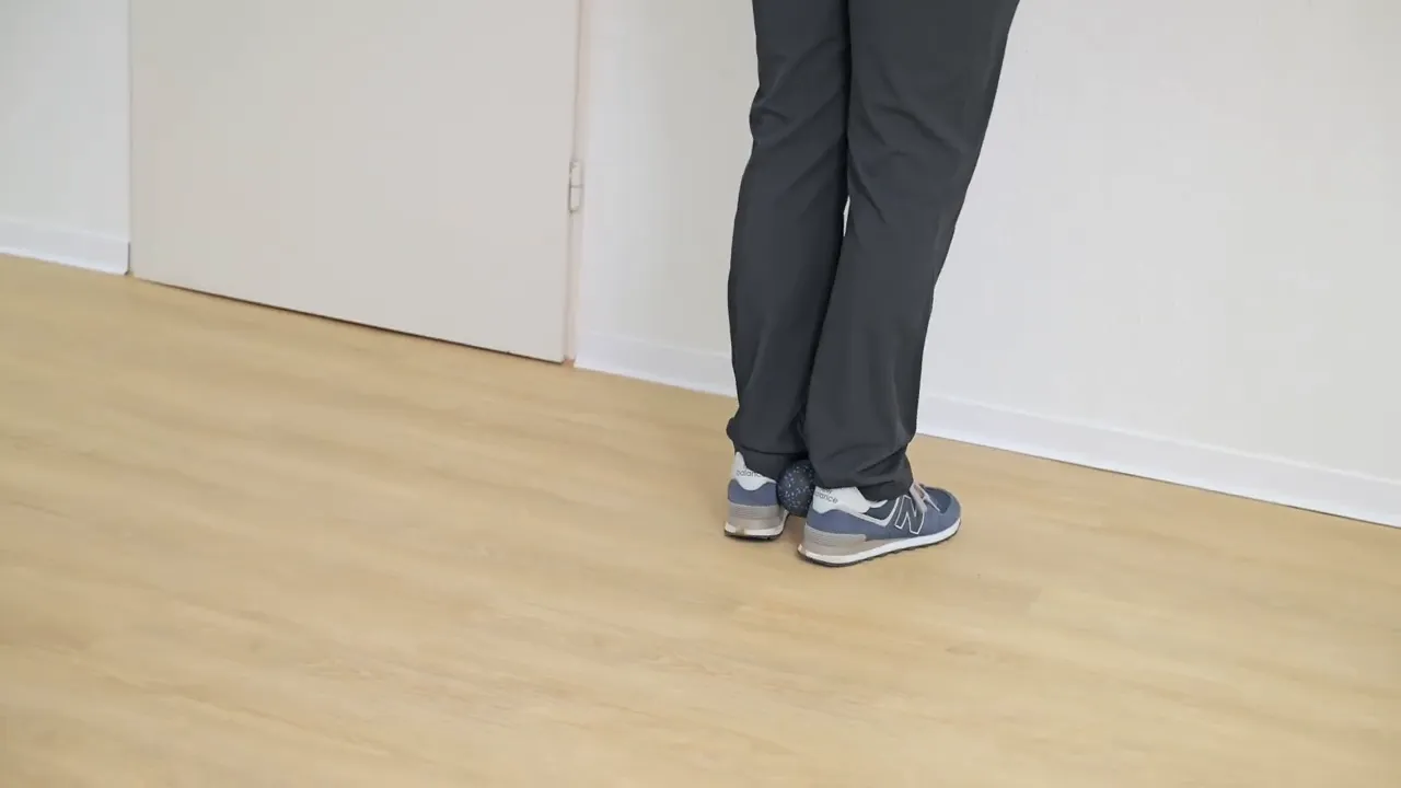 Nahaufnahme: Ball zwischen den Fersen als Ausgangsposition für die Wadenaktivierung ohne Kniebelastung