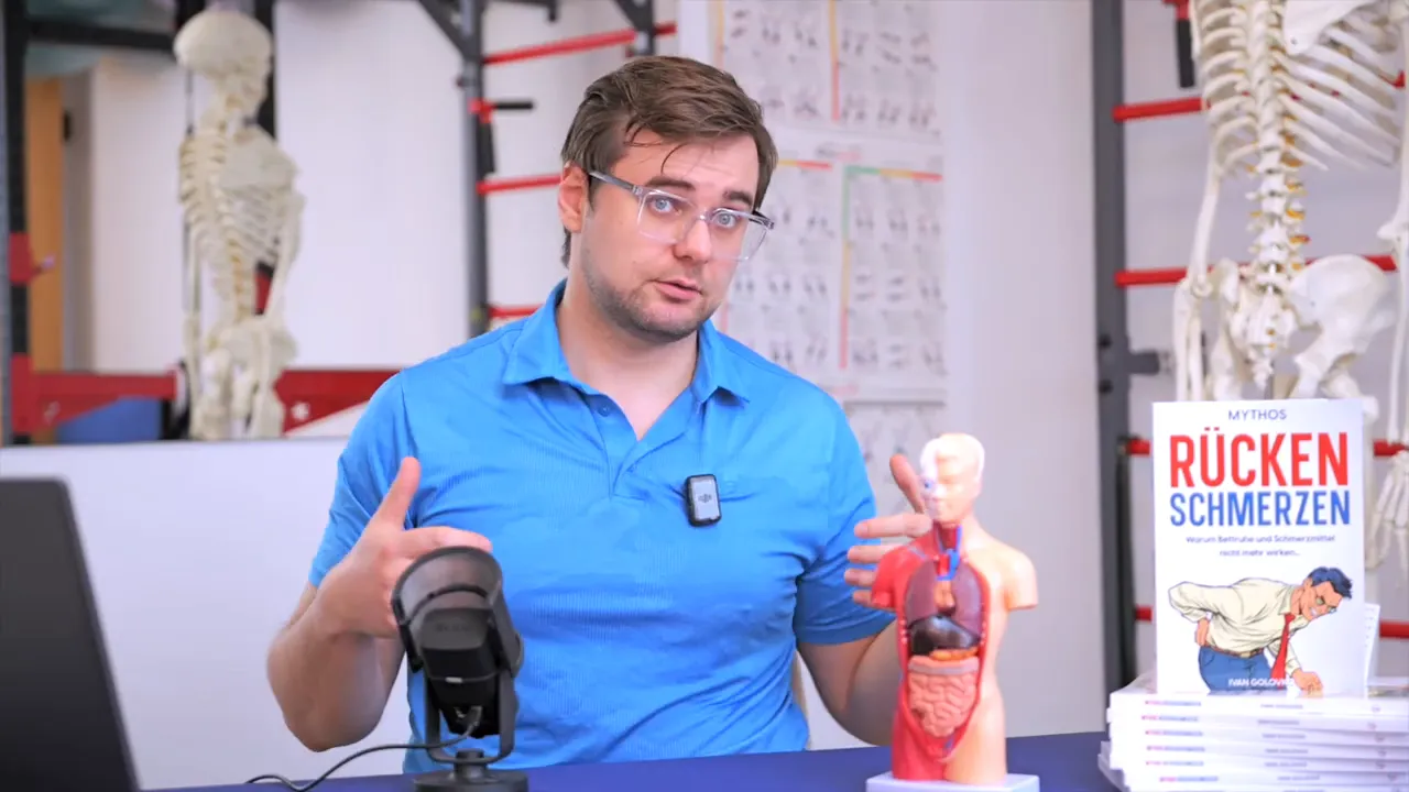 Therapeut erklärt hormonelle Einflüsse auf Rückenbeschwerden mit anatomischem Torso und Buch