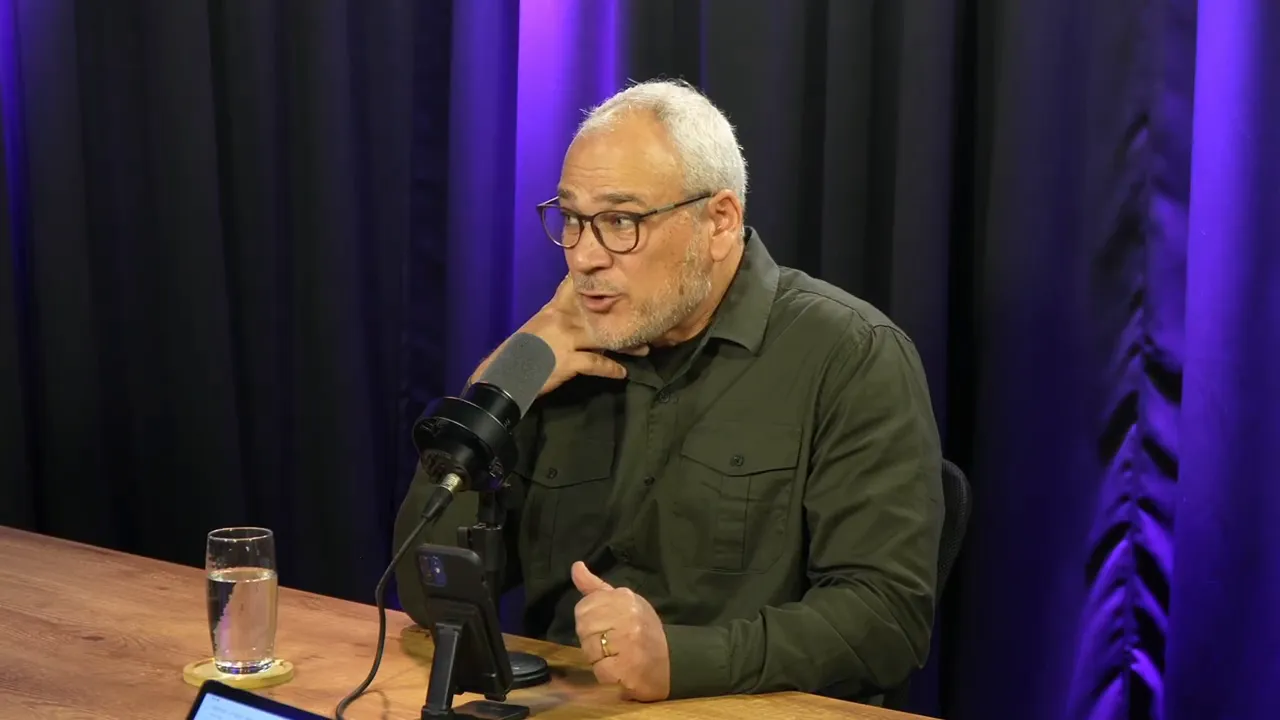 apresentador atento com a mão no rosto em estúdio, demonstrando escuta ativa