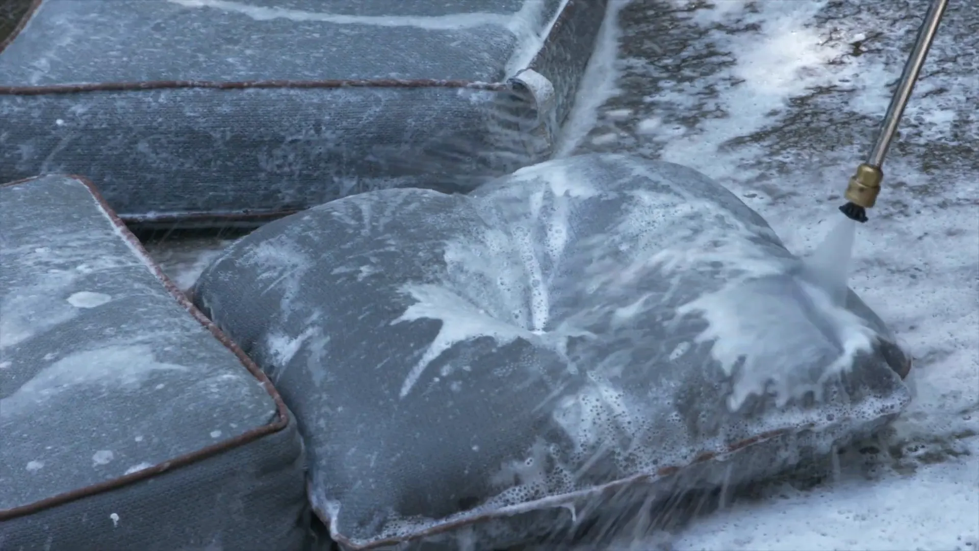 Spraying outdoor cushions with a pressure washer