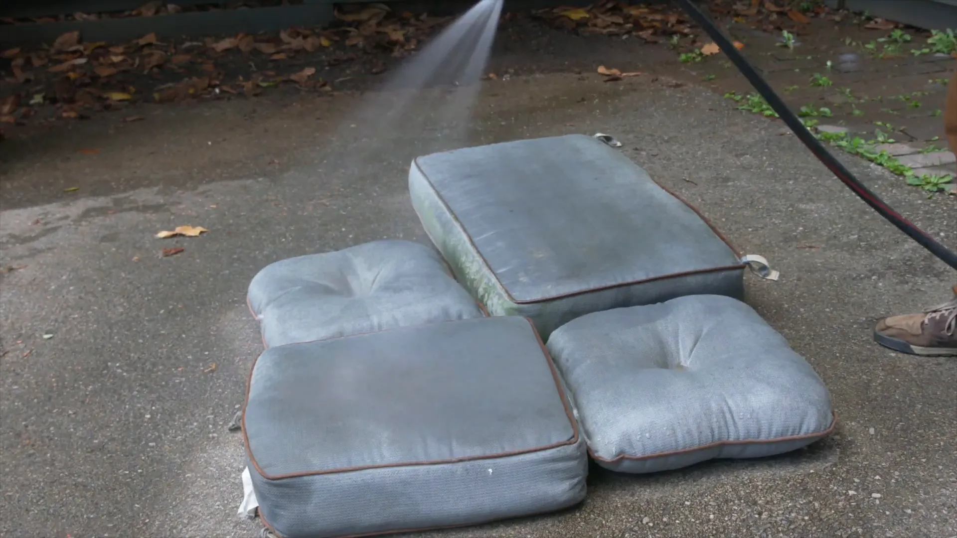 Spraying down outdoor cushions with water