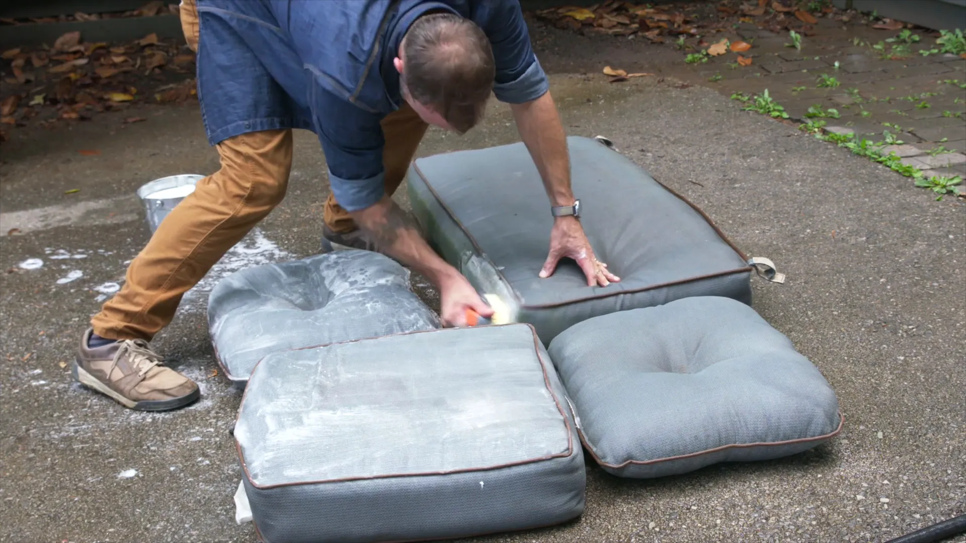 Applying cleaning solution to outdoor cushions