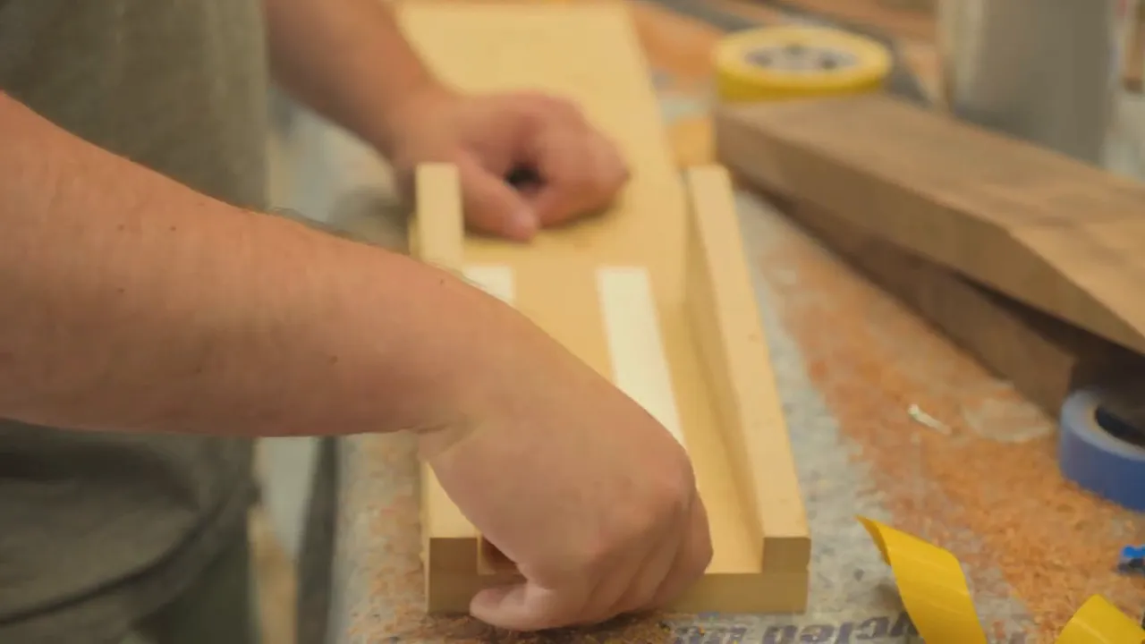 Guitar neck blank being positioned against a scarf-joint fixture