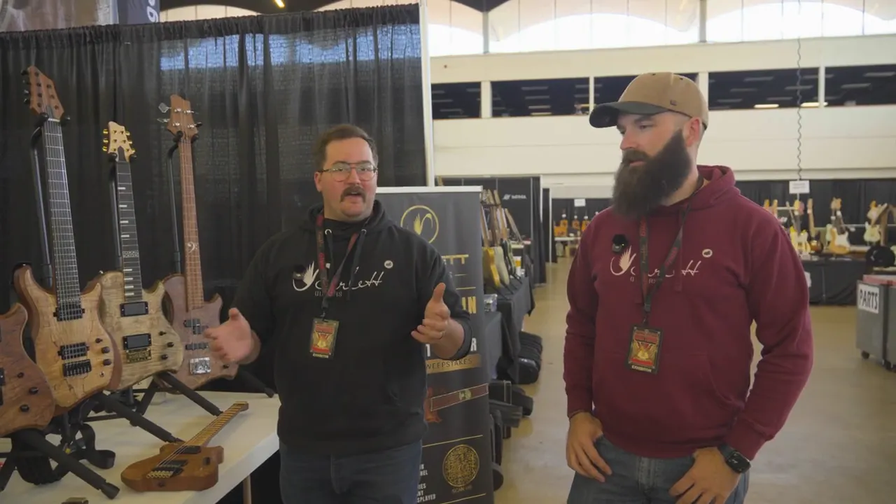 Two custom guitar builders standing at a booth during the Dallas International Guitar Festival