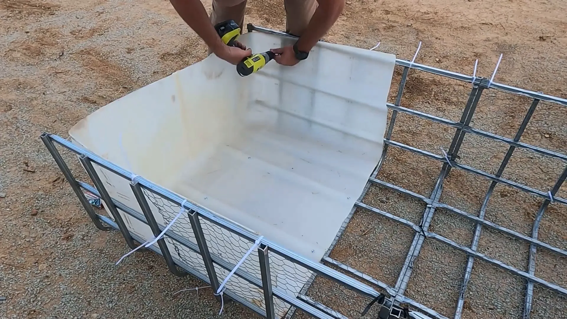 man wrapping chicken wire inside the diy chicken tractor