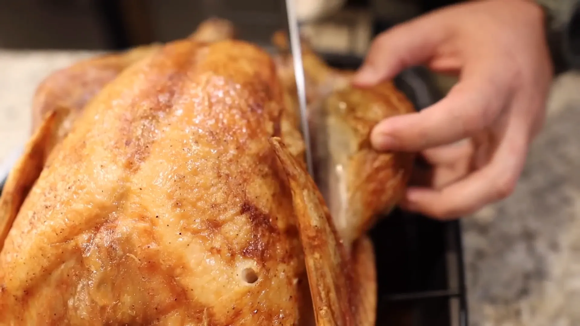 Making the first cut between the drumstick and breast
