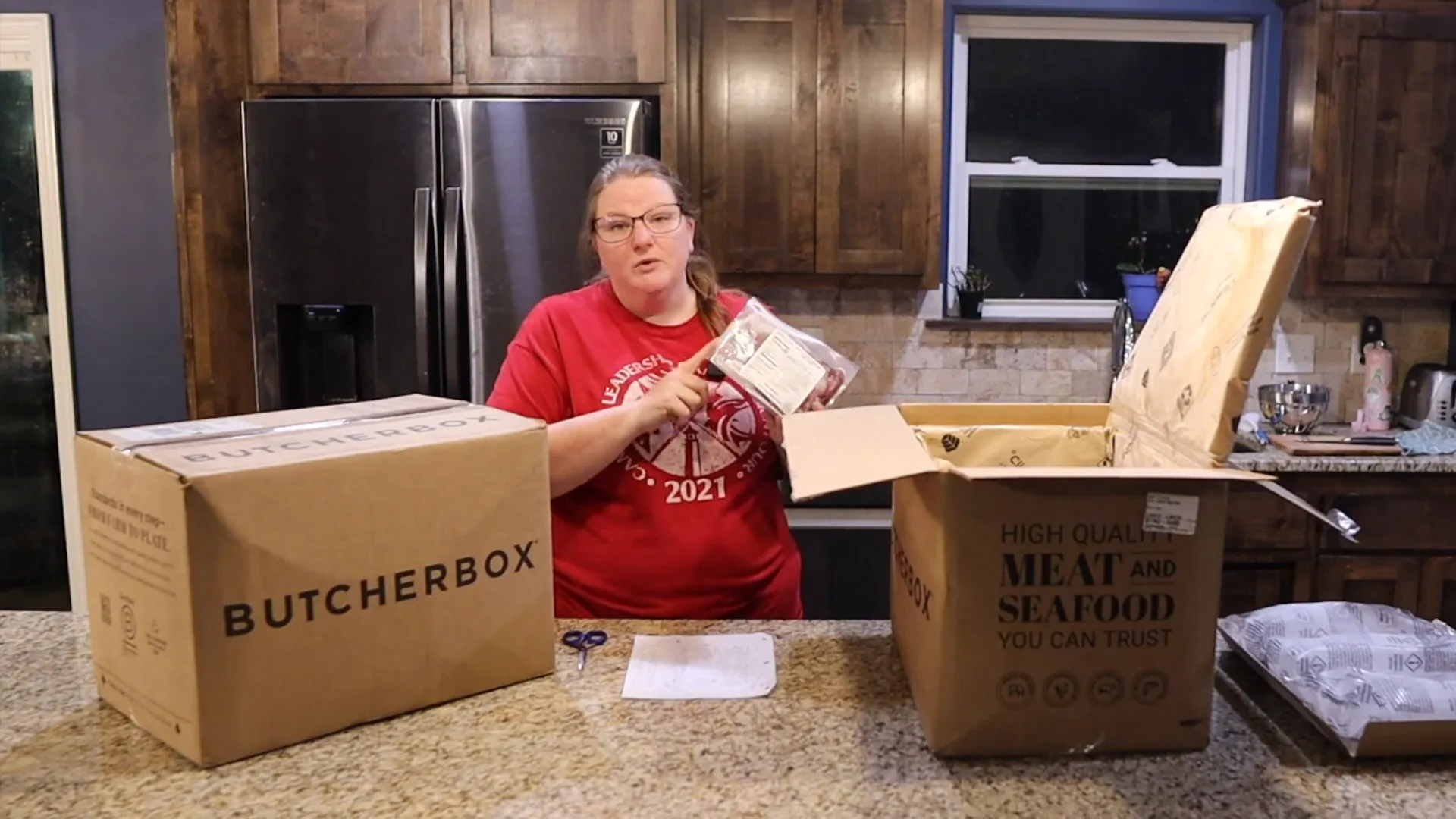 Woman showing types of meat included in the ButcherBox