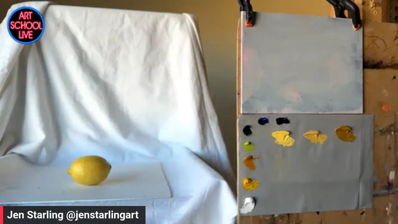 Yellow lemon on white draped fabric beside a palette with yellow paint mixtures