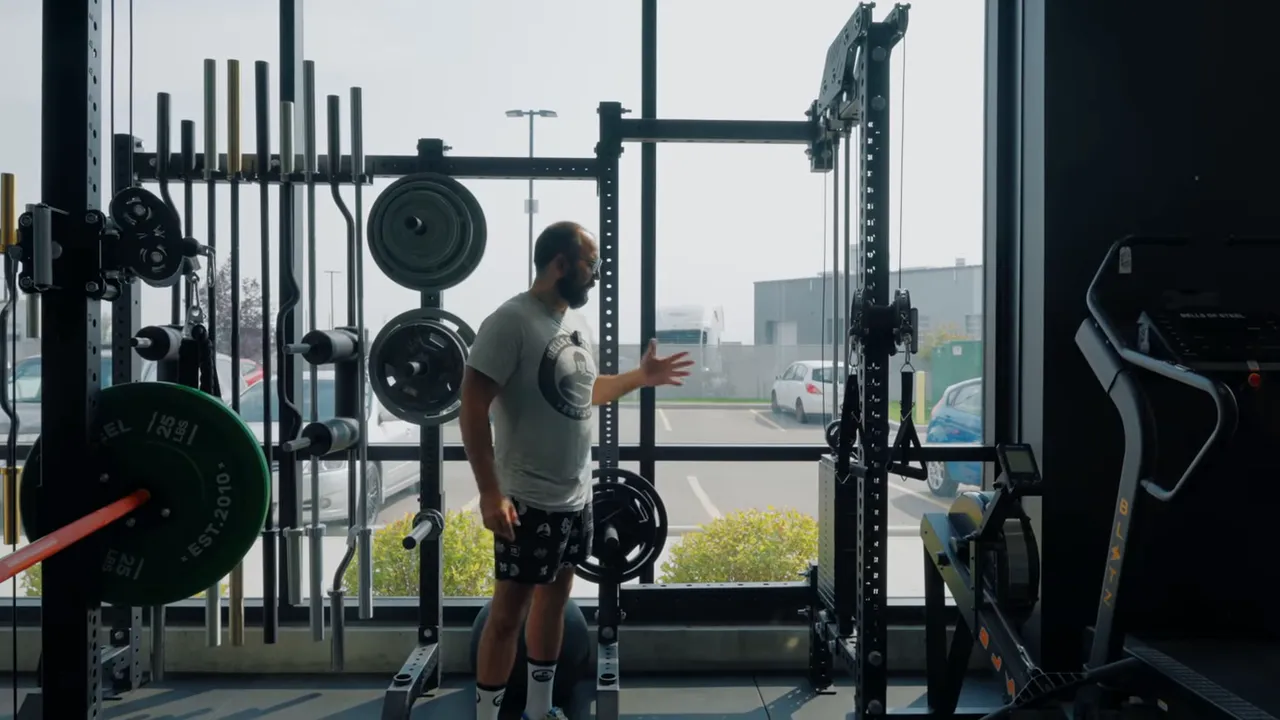 Wide view of the rack and storage area showing uprights, plates, and accessory mounting points.