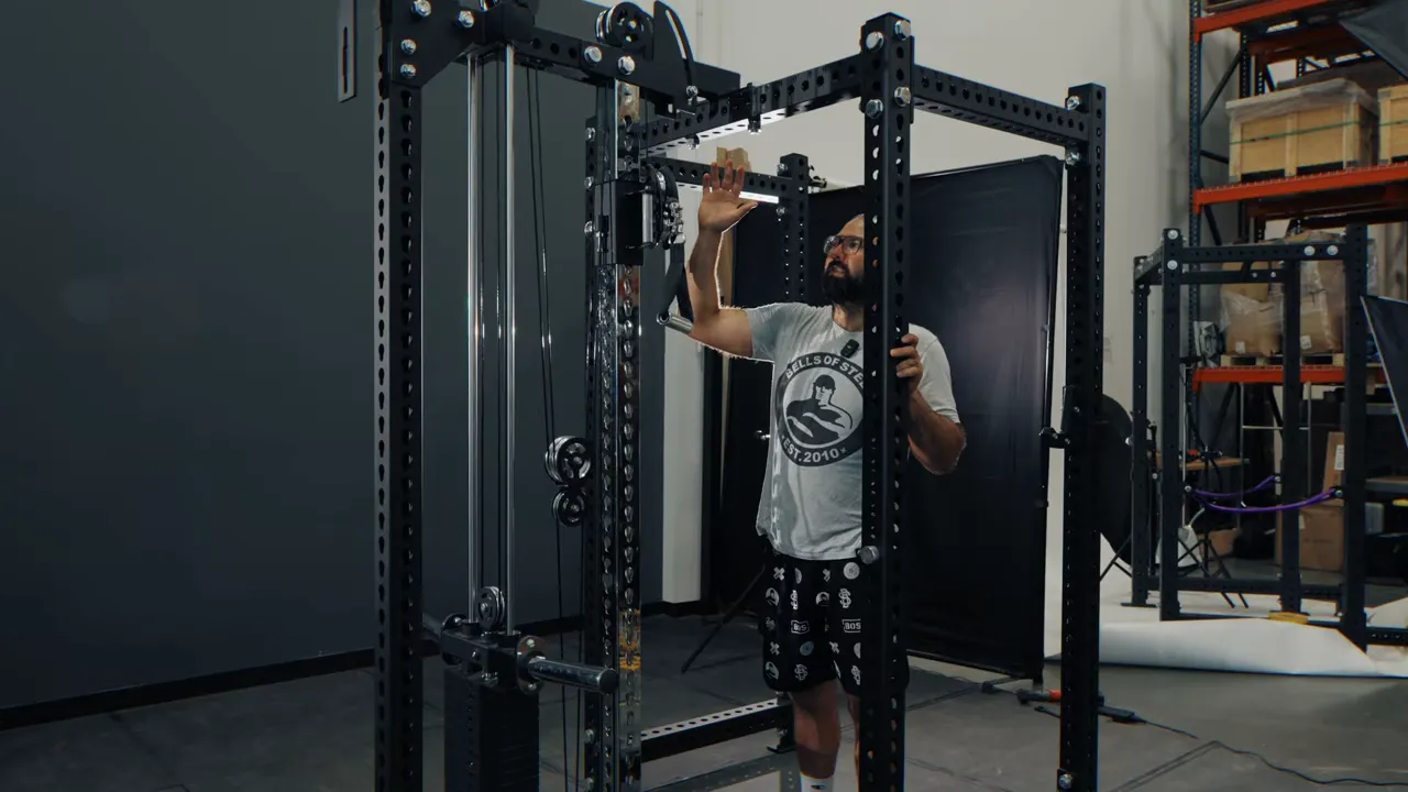 Clear view of the Oblivion Tower center mount attached to a power rack with pulleys and curved slot bracket visible.