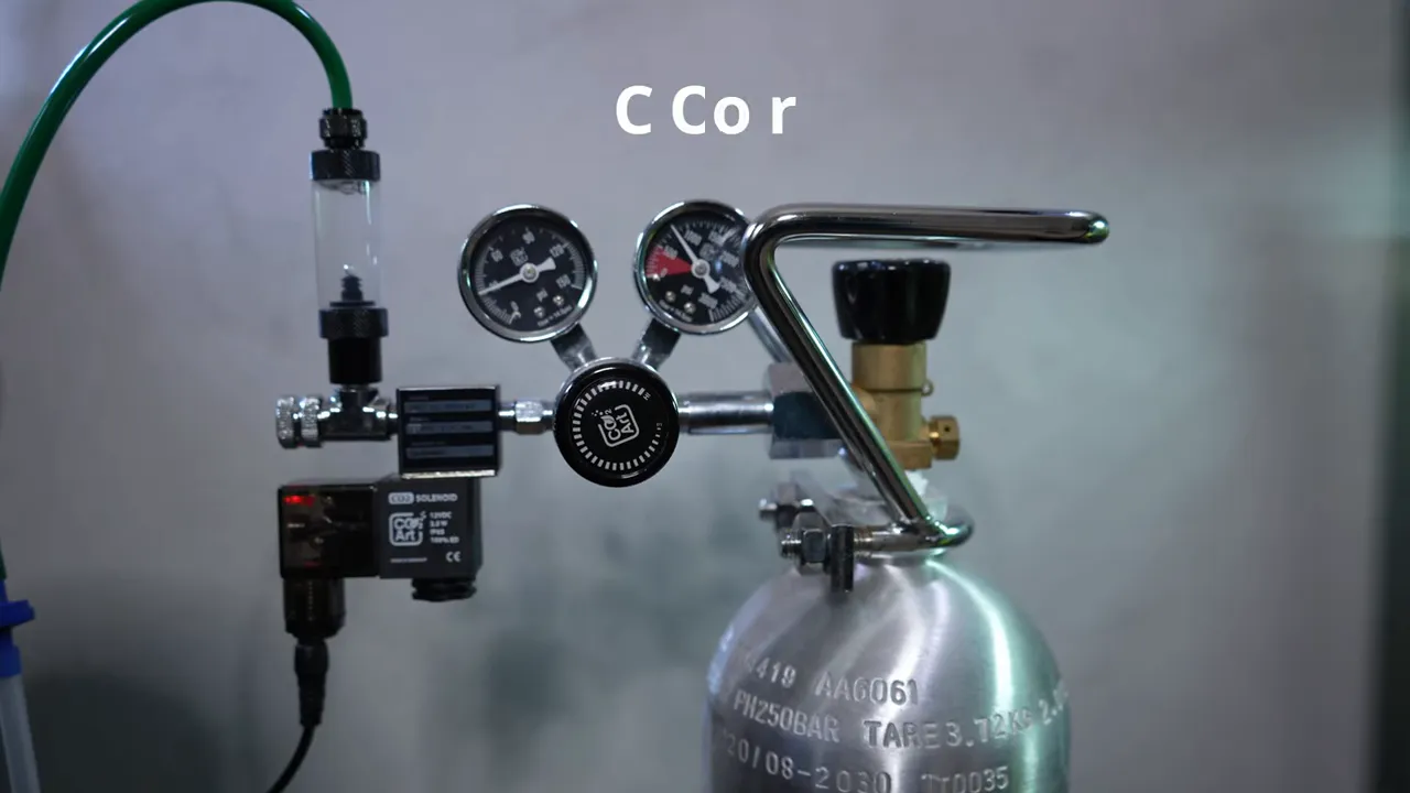CO2 regulator attached to a silver cylinder with pressure gauges and tubing