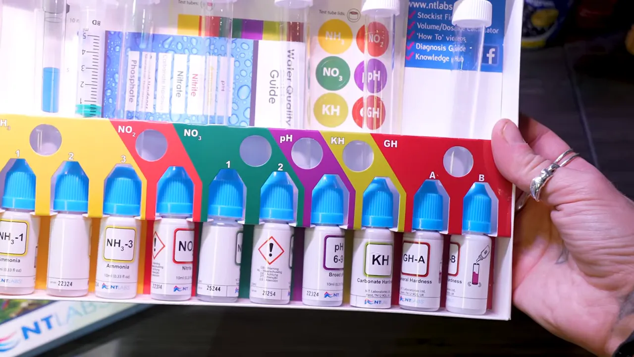 Open aquarium test kit with labelled liquid reagent bottles and test tubes