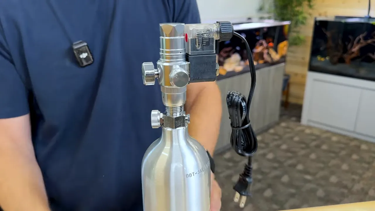 CO2 regulator and solenoid attached to an upright aluminium cylinder