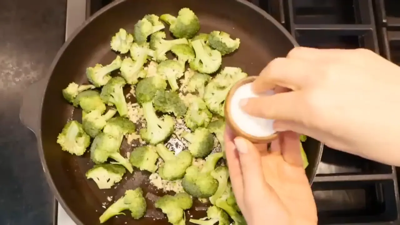 Sautéing garlic and broccoli in the skillet