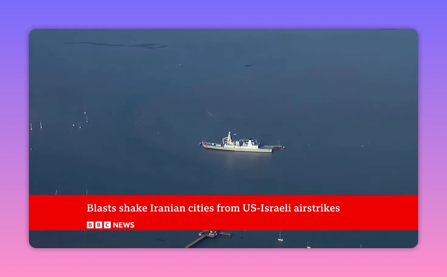 Navire militaire isolé en mer, prise depuis les airs, bande d'information BBC en bas