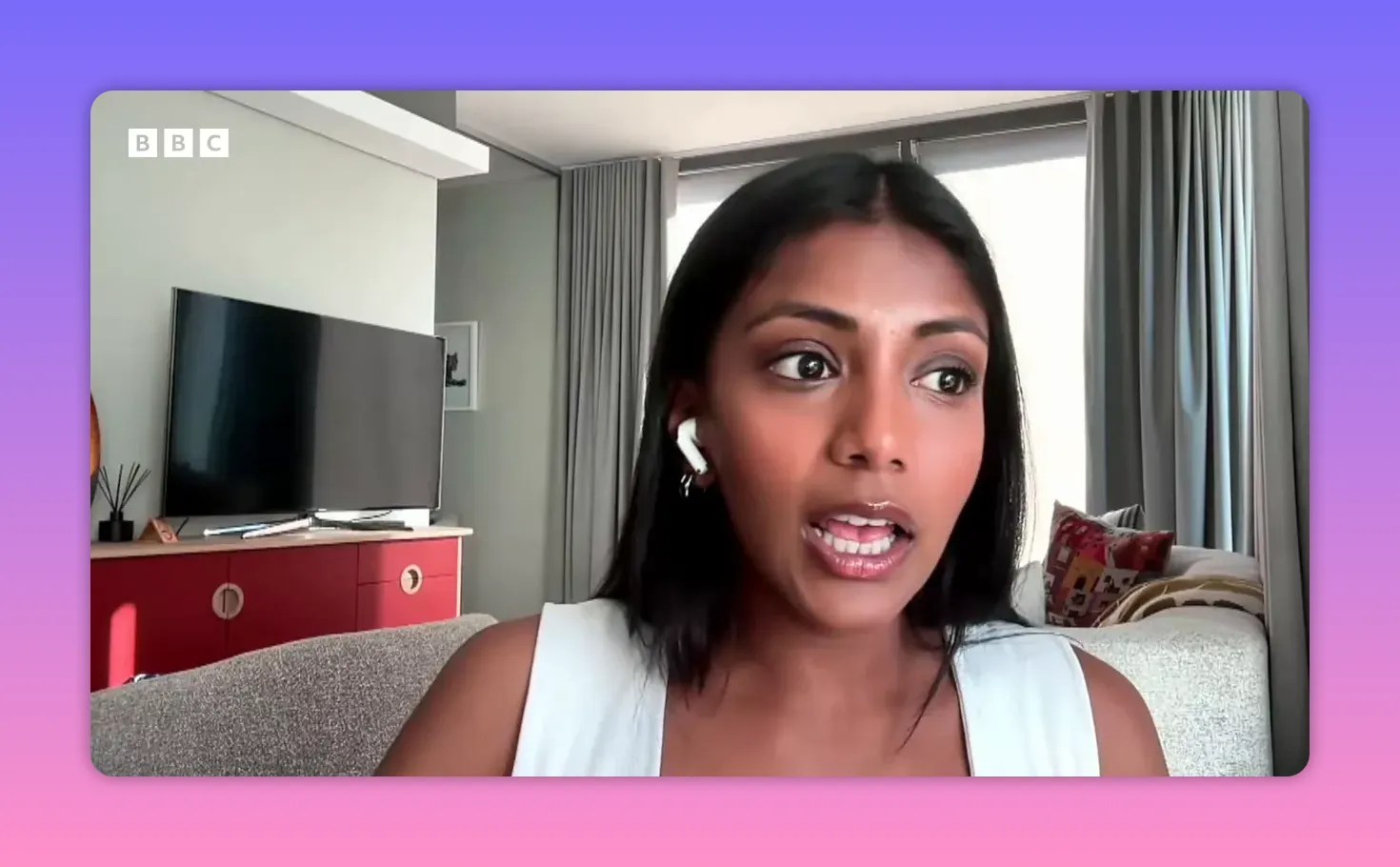 Intervenante en visioconférence, plan rapproché dégagé montrant un salon en arrière‑plan, expression engagée en parlant.