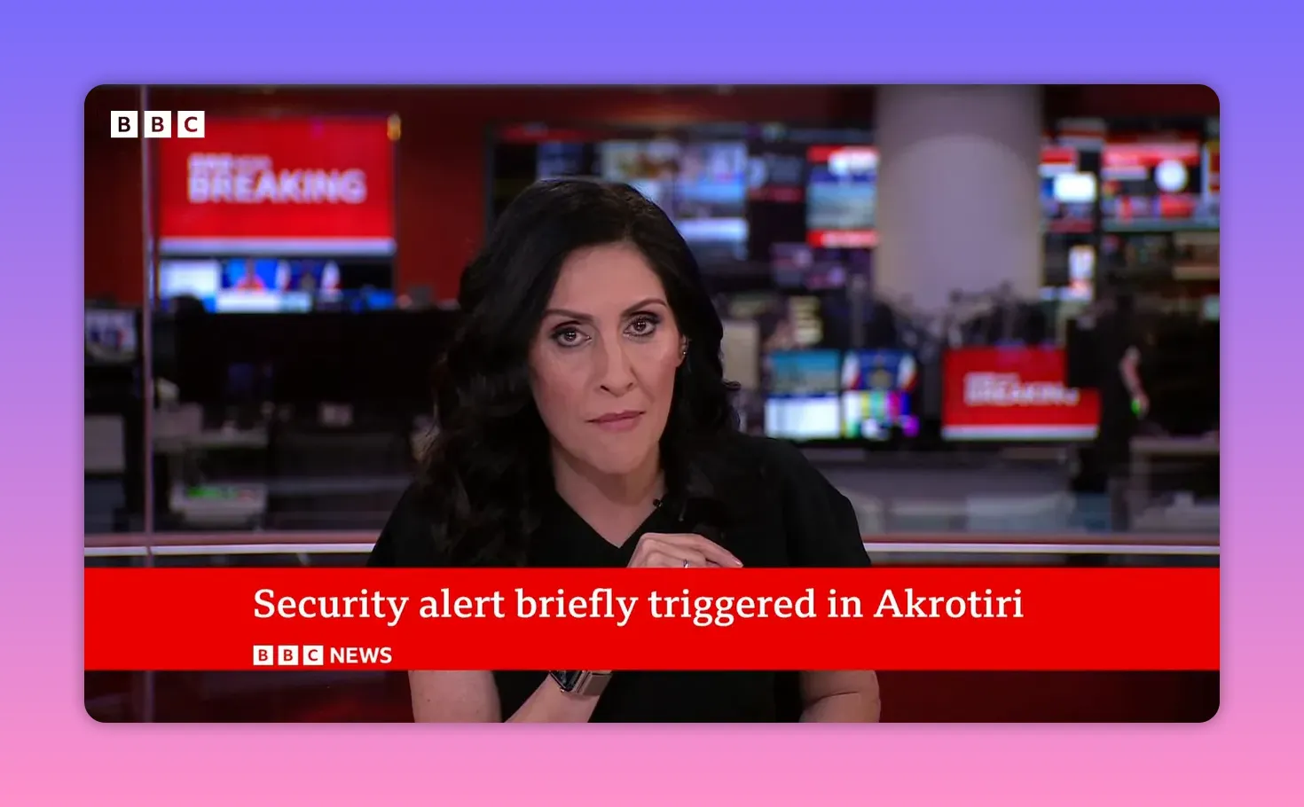 Présentatrice en plateau avec bande rouge indiquant 'Security alert briefly triggered in Akrotiri' et écrans de contrôle en arrière-plan