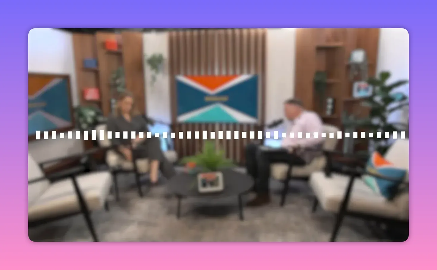 Set de podcast légèrement flou montrant deux animateurs et une visualisation audio discrète