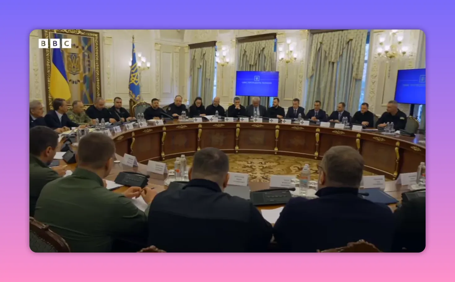 Vue large d'une réunion gouvernementale dans une salle ornée avec table circulaire et drapeaux