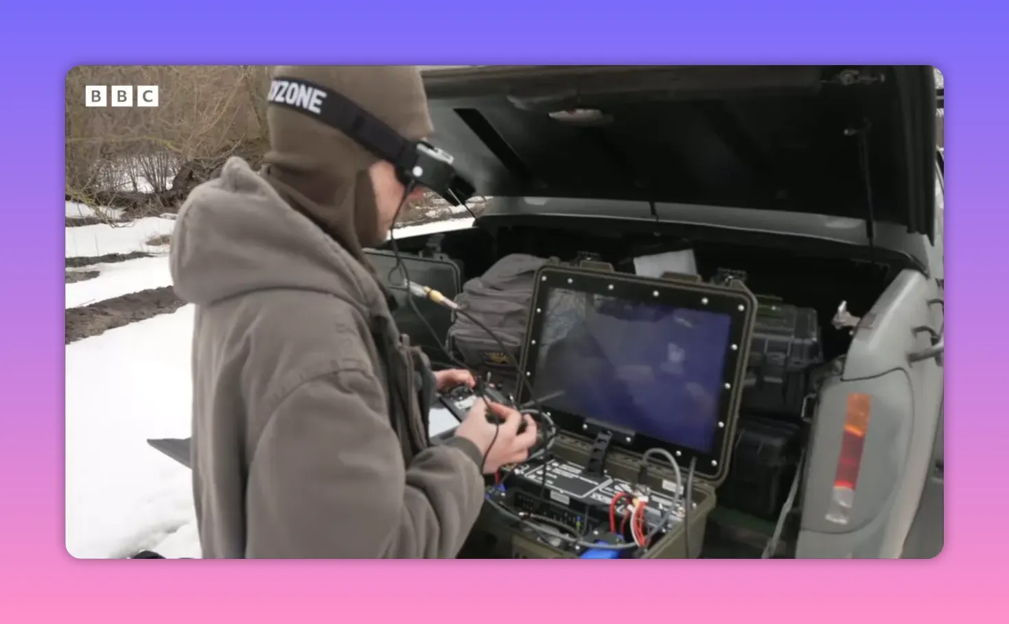 opérateur avec lunettes FPV devant une station de contrôle ouverte, radiocommande et écran visibles