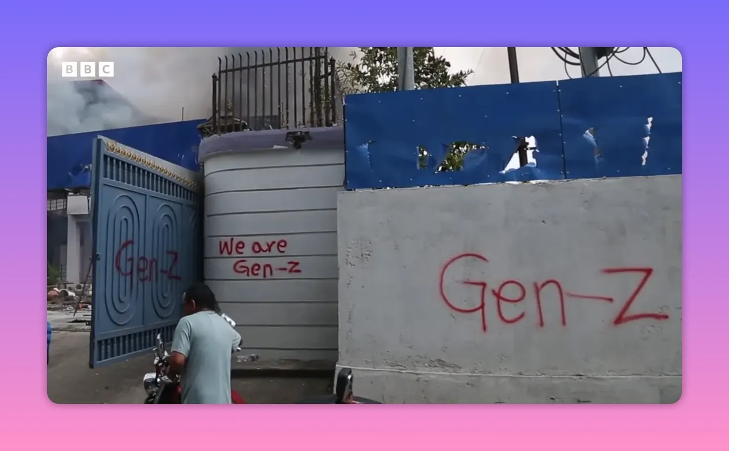 Mur et portail tagués 'Gen‑Z' avec fumée en arrière-plan, illustrant l'engagement des jeunes manifestants