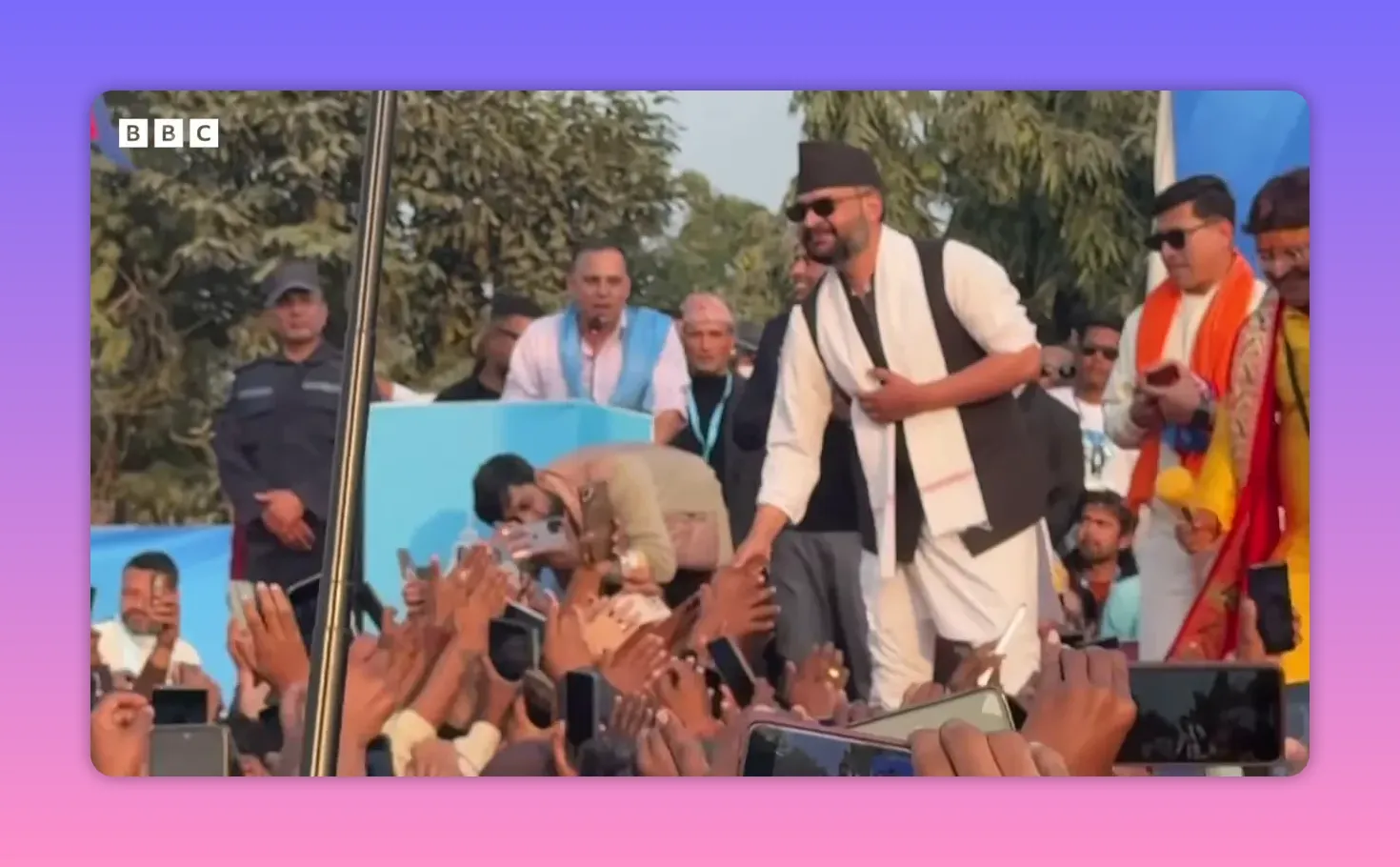 Balen Shah en tenue traditionnelle tendant la main vers la foule de supporters qui lèvent leurs téléphones