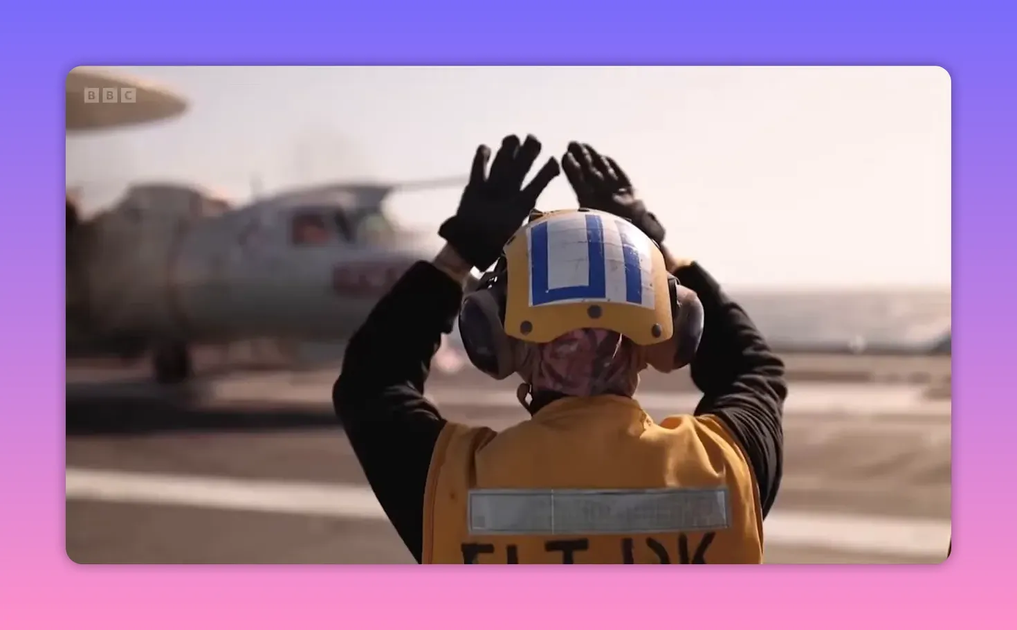 Membre d'équipage guidant une opération de décollage sur le pont d'un porte‑avions