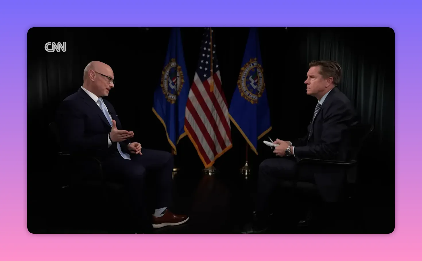 Zwei Gesprächspartner in einem formellen Interview, US-Flagge mittig