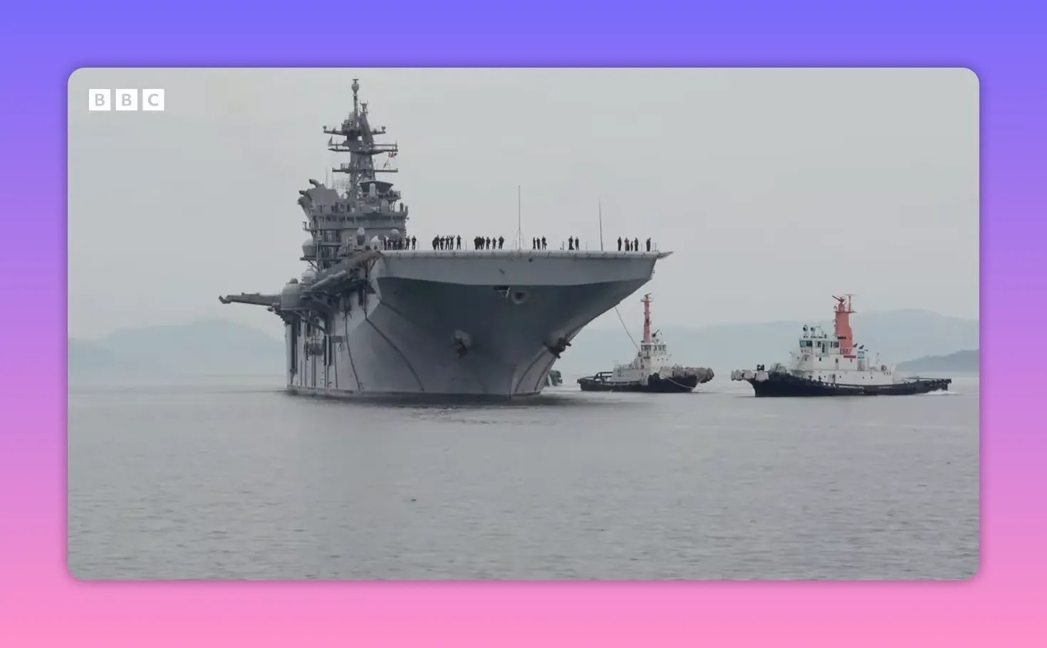 Groupe amphibie vu de face avec remorqueurs et matelots sur le pont