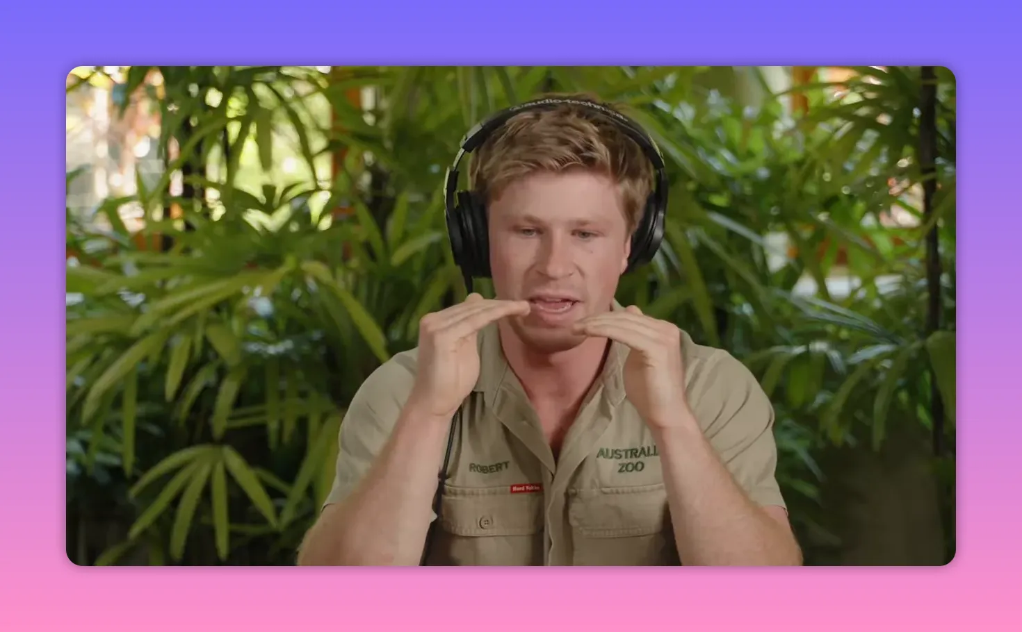 Person mit Kopfhörern gestikulierend vor Pflanzenhintergrund im Interview