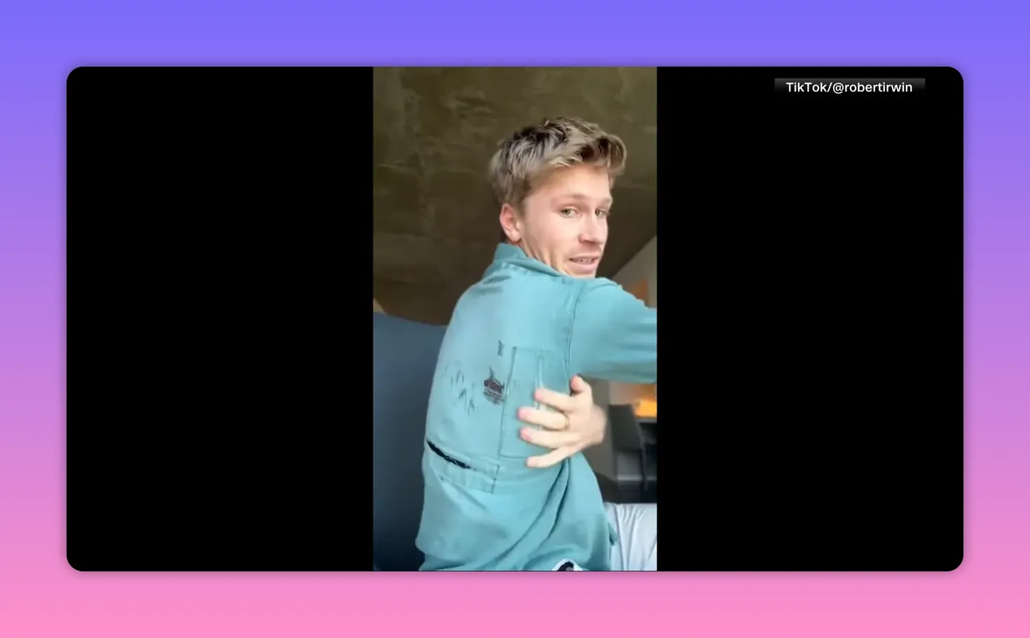 Person dreht sich und zeigt die Rückseite eines blauen Hemds mit sichtbaren Flecken und Rissen.