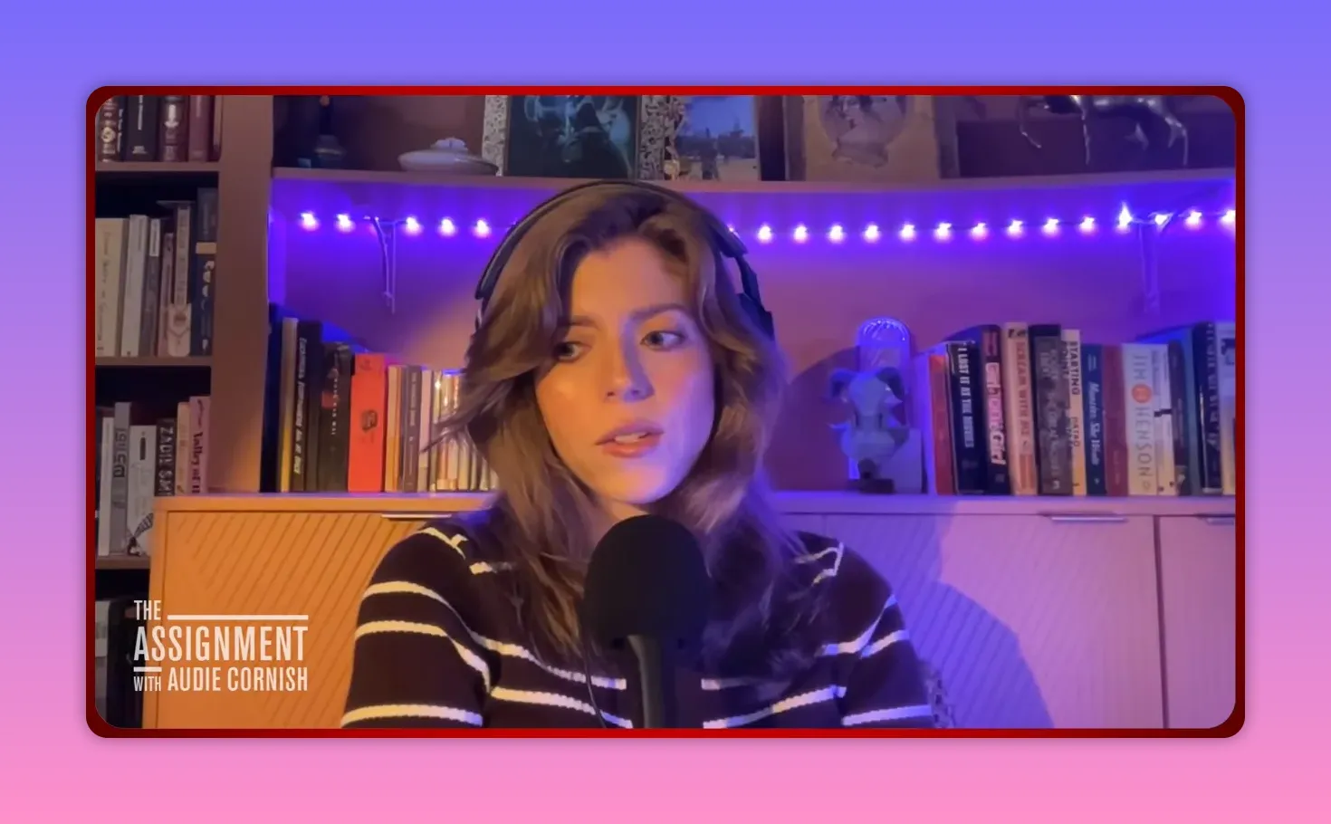 Single podcast guest seated in front of bookshelf with purple LED lighting and microphone