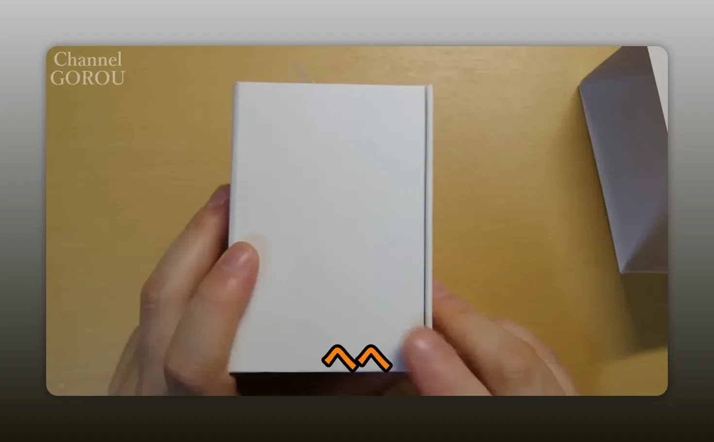 Bowers & Wilkins Pi7の白い外箱を正面から持ち、蓋がしっかり閉まっている様子