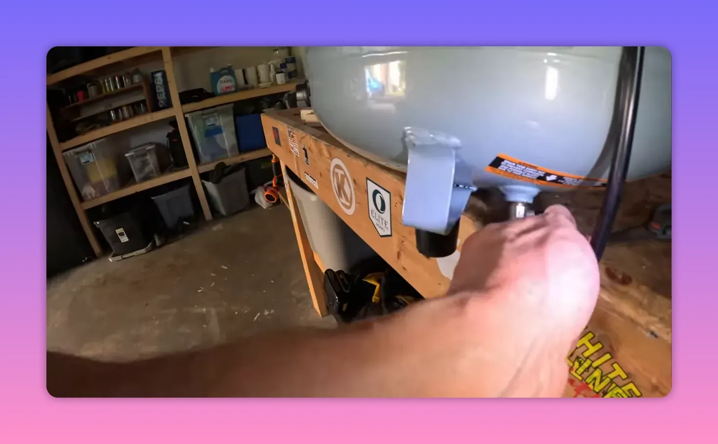 hand opening the drain/purge valve on the bottom of a pancake air compressor tank to release water