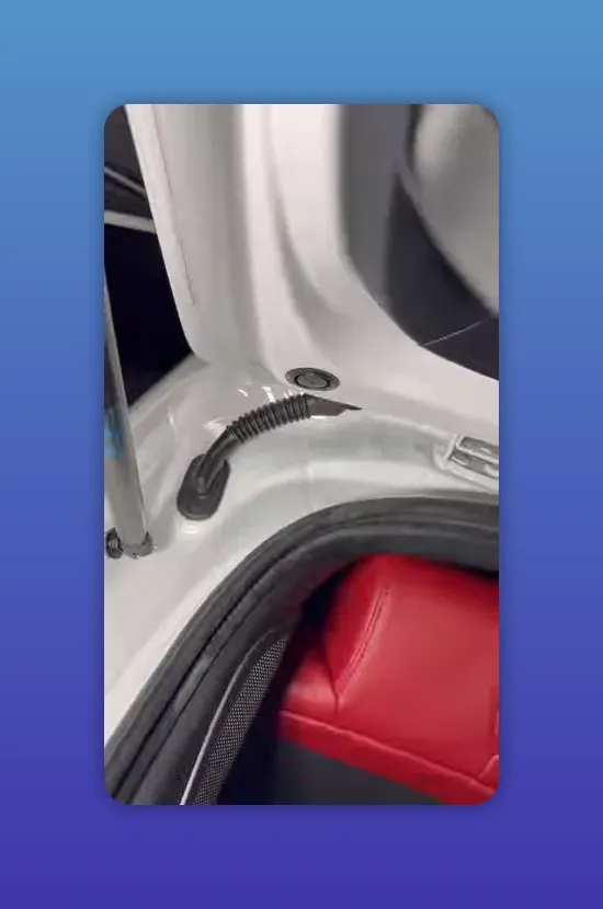 Close-up of factory hatch grommet with dash cam wiring routed through the OEM opening on an Acura Integra Type S.