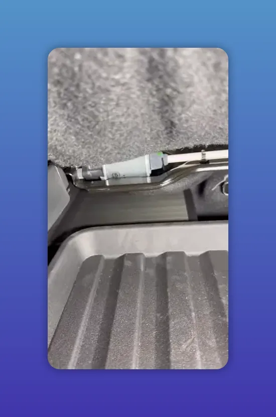 Under-seat view after moving the seat forward showing wiring and connector with clear space for a battery pack