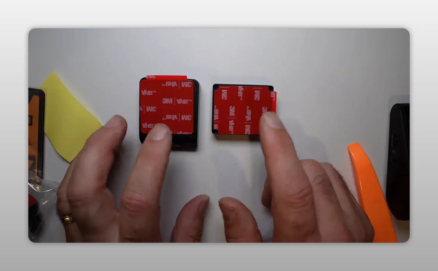 Two dash cam mounts with fresh red 3M adhesive pads attached