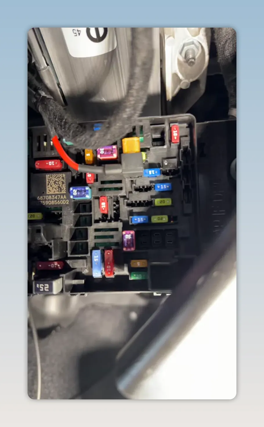 Ram 1500 interior fuse panel with coloured fuses and a red fuse tap