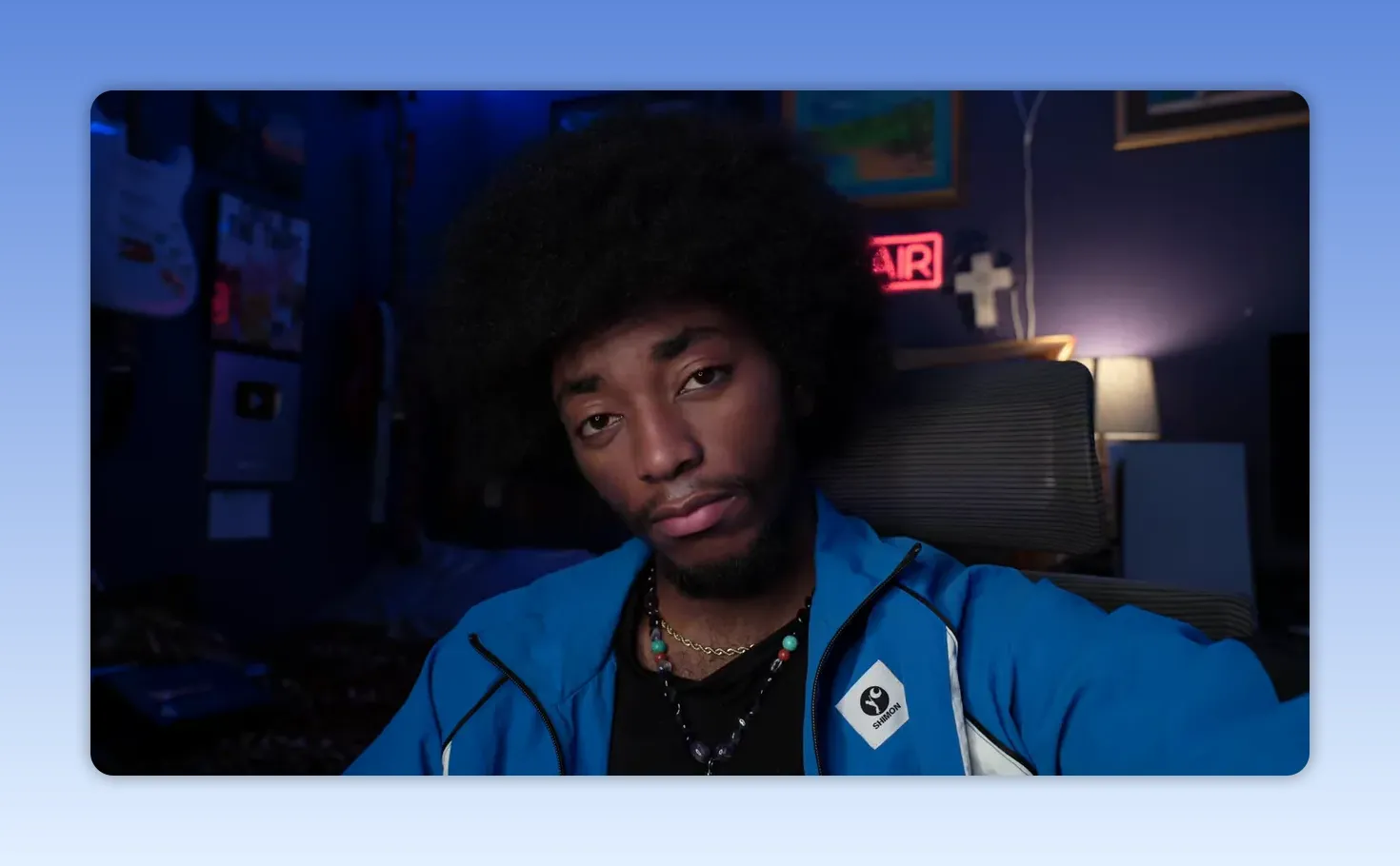 plan rapproché d'une personne regardant la caméra, expression calme et confiante en veste bleue