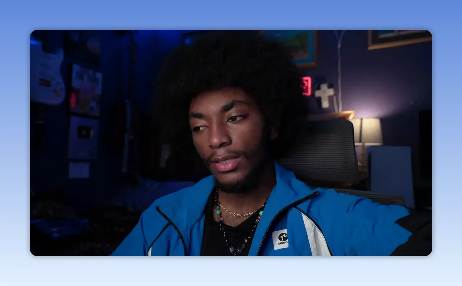 Portrait clair d'un homme en veste bleue, regard pensif et légèrement détourné, éclairage d'ambiance