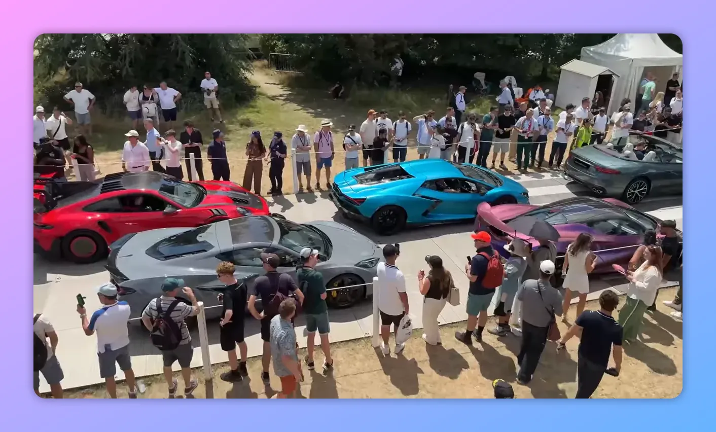Panoramica della linea di supercar colorate parcheggiate sulla passerella con spettatori in piedi ai lati al Goodwood Festival of Speed.