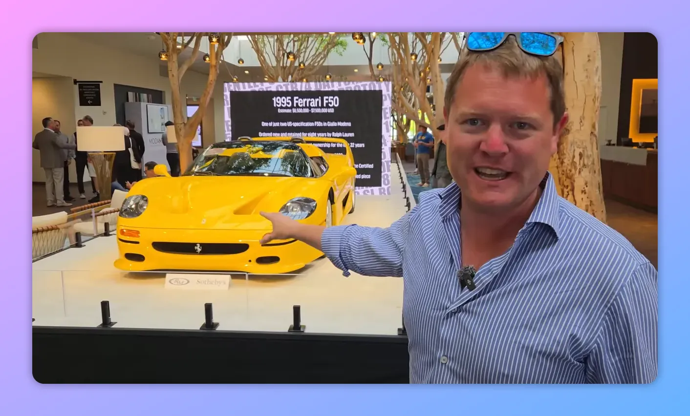 Presentatore che indica una Ferrari F50 gialla esposta con il cartello informativo sullo sfondo