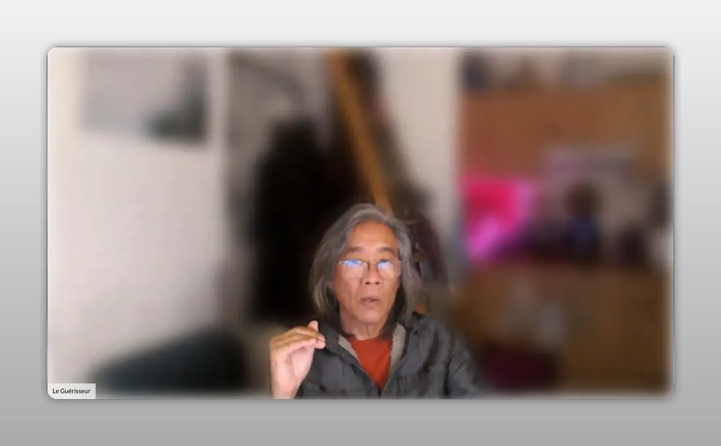 Intervenant en webcam, torse détendu et geste calme, visage centré et net sur fond flou — image illustrant la volonté sereine (Zhi) plutôt que la contrainte.