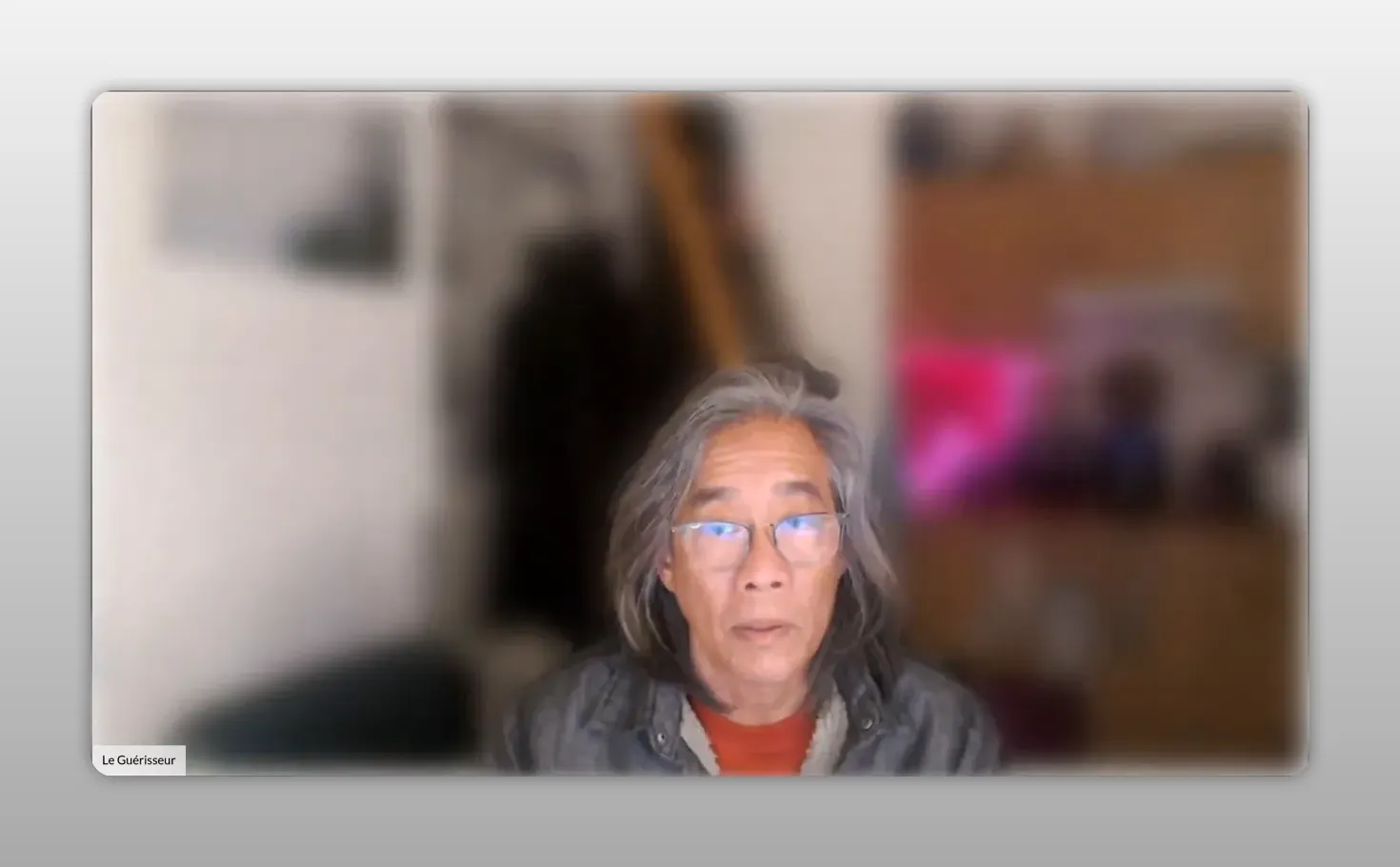 Intervenant en webcam, visage centré, expression neutre, arrière‑plan flou