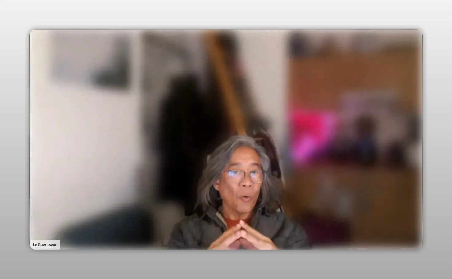 Orateur en webcam, mains jointes en triangle pour illustrer l'alignement, fond flou