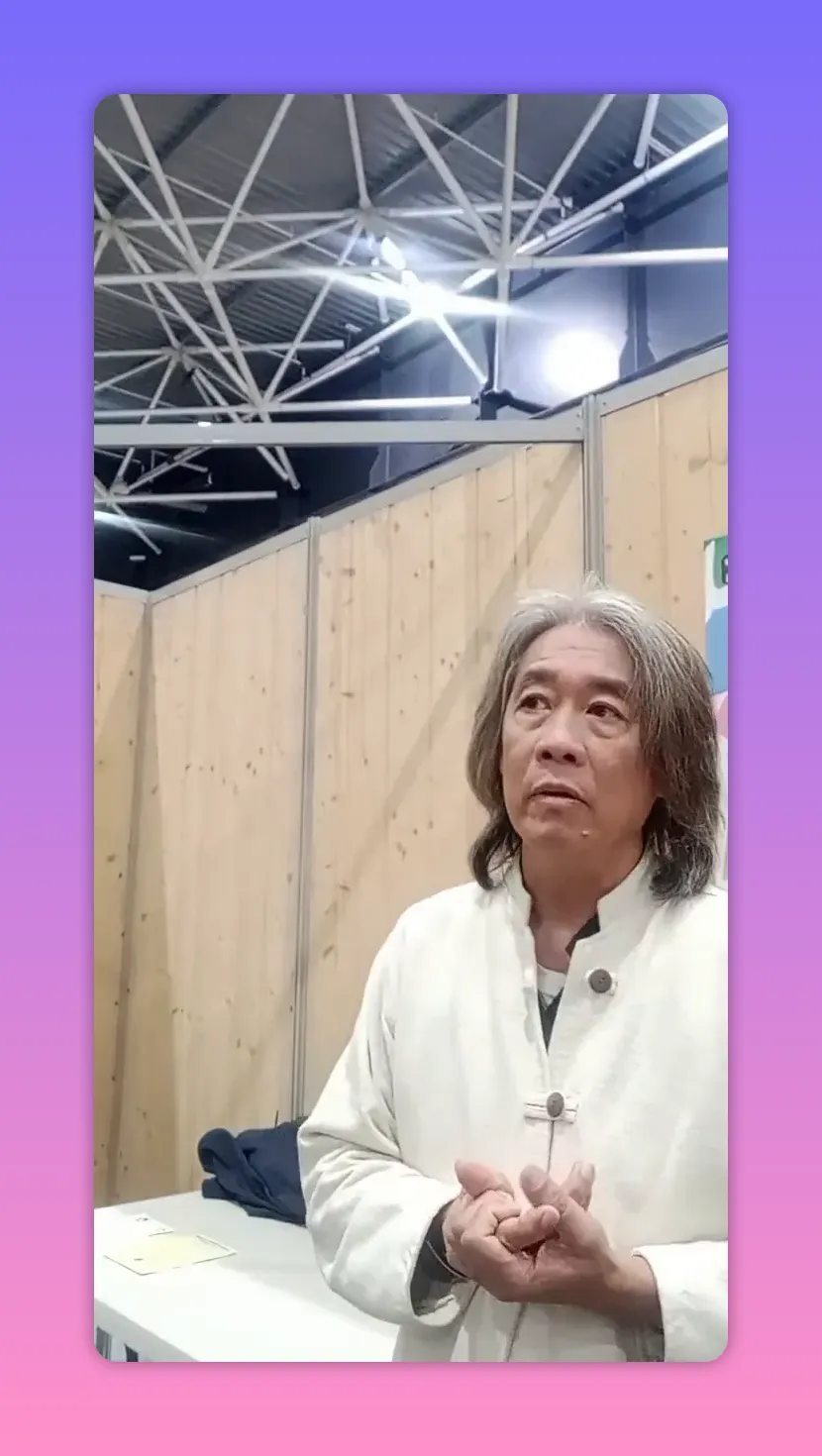 Personne debout de trois-quarts, buste bien droit et mains jointes au centre, expression attentive, fond en panneaux de bois.