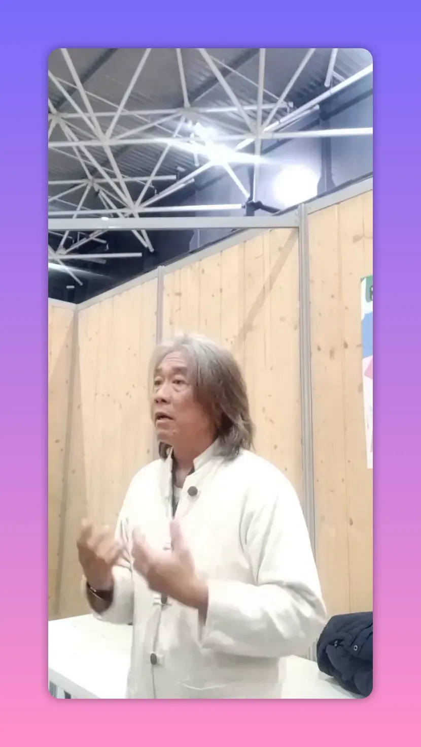 Intervenant montrant un geste ouvert avec les mains, torse visible, fond en panneaux de bois.