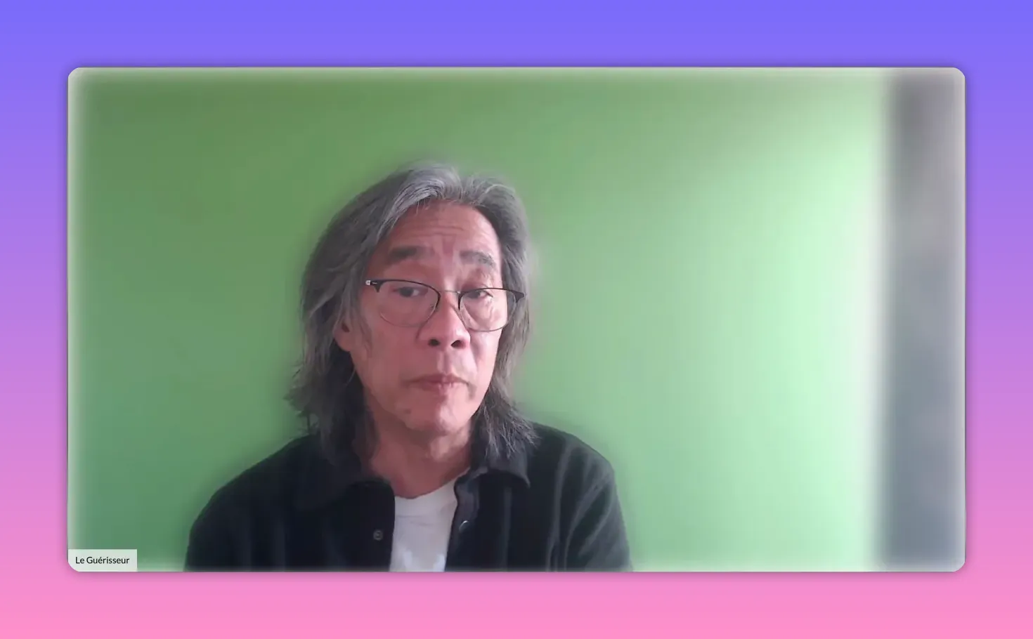 intervenant en plan moyen devant un mur vert, expression neutre et claire